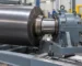 Technician inspecting bearing housing on an illustrative rubber mixing mill