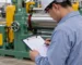 Buyer checking a safety test list beside a rubber mixing mill